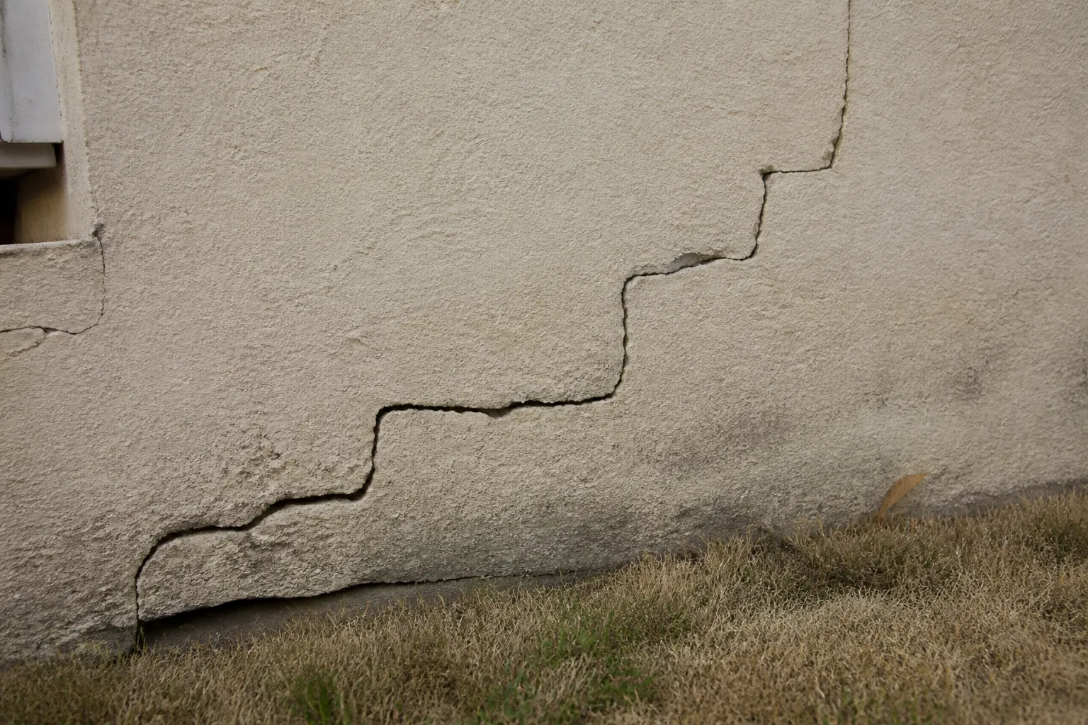 Fissure en escalier observée sur un mur de maison après un été sec