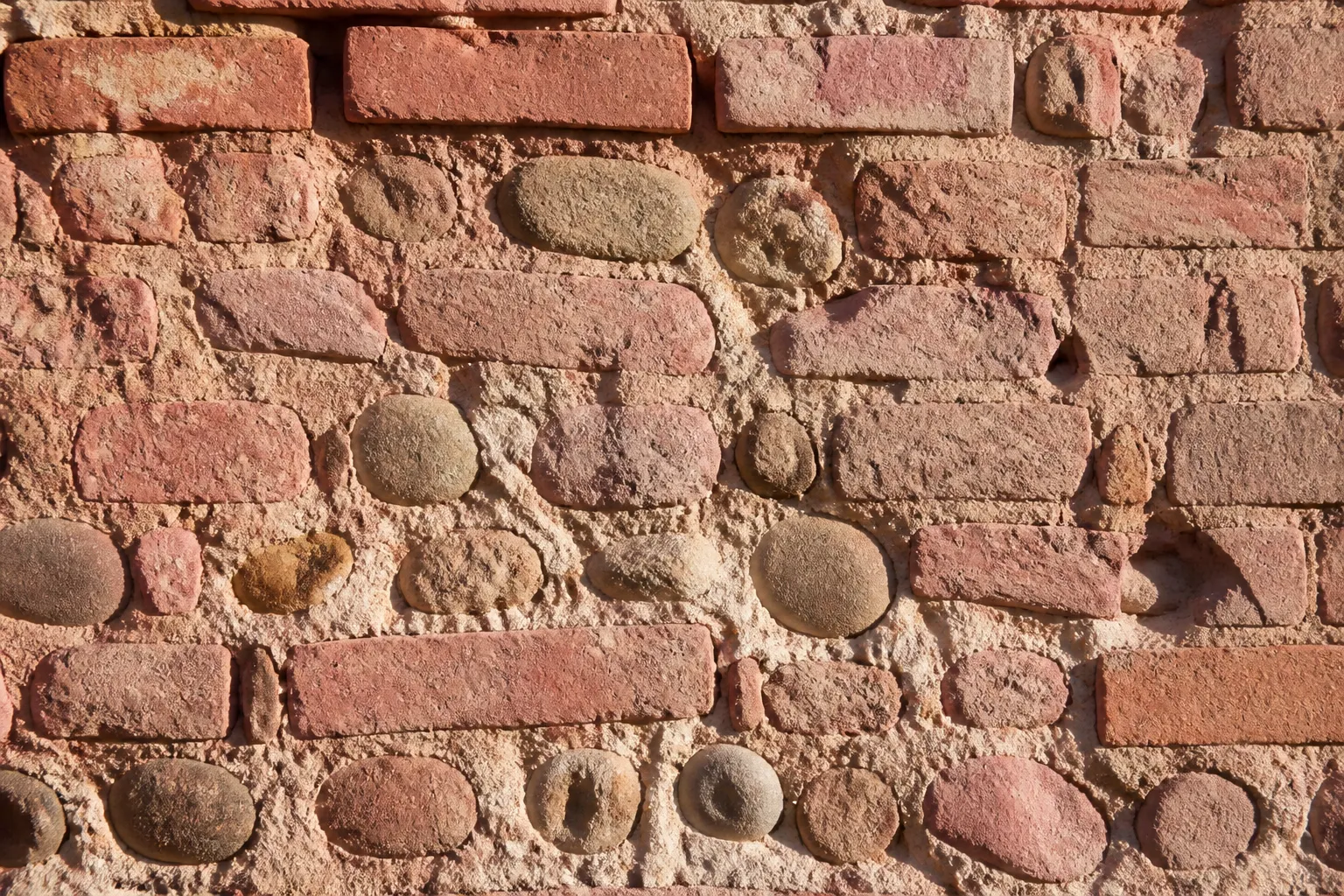 Mur ancien en brique foraine et galets