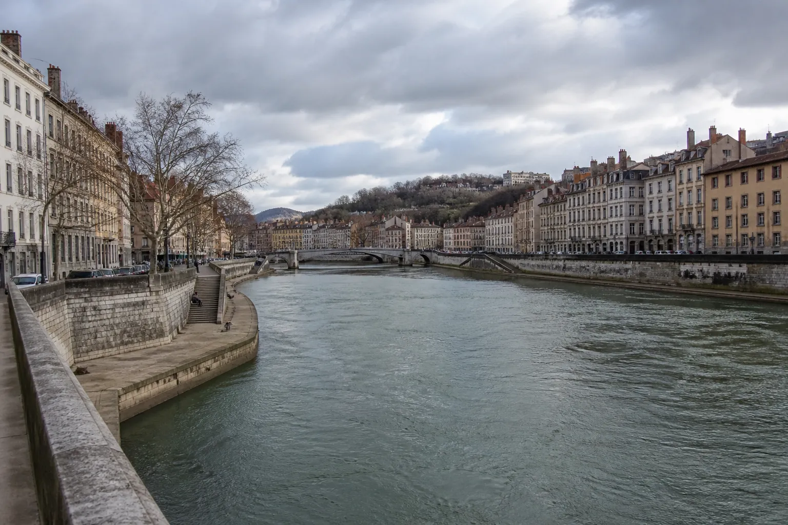 Rivière large traversant une ville moyenne, quais et immeubles