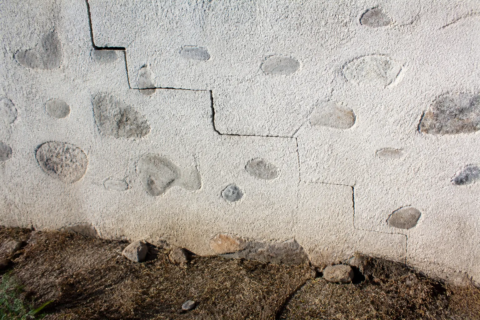 Mur de maison avec fissure en escalier et sol sec