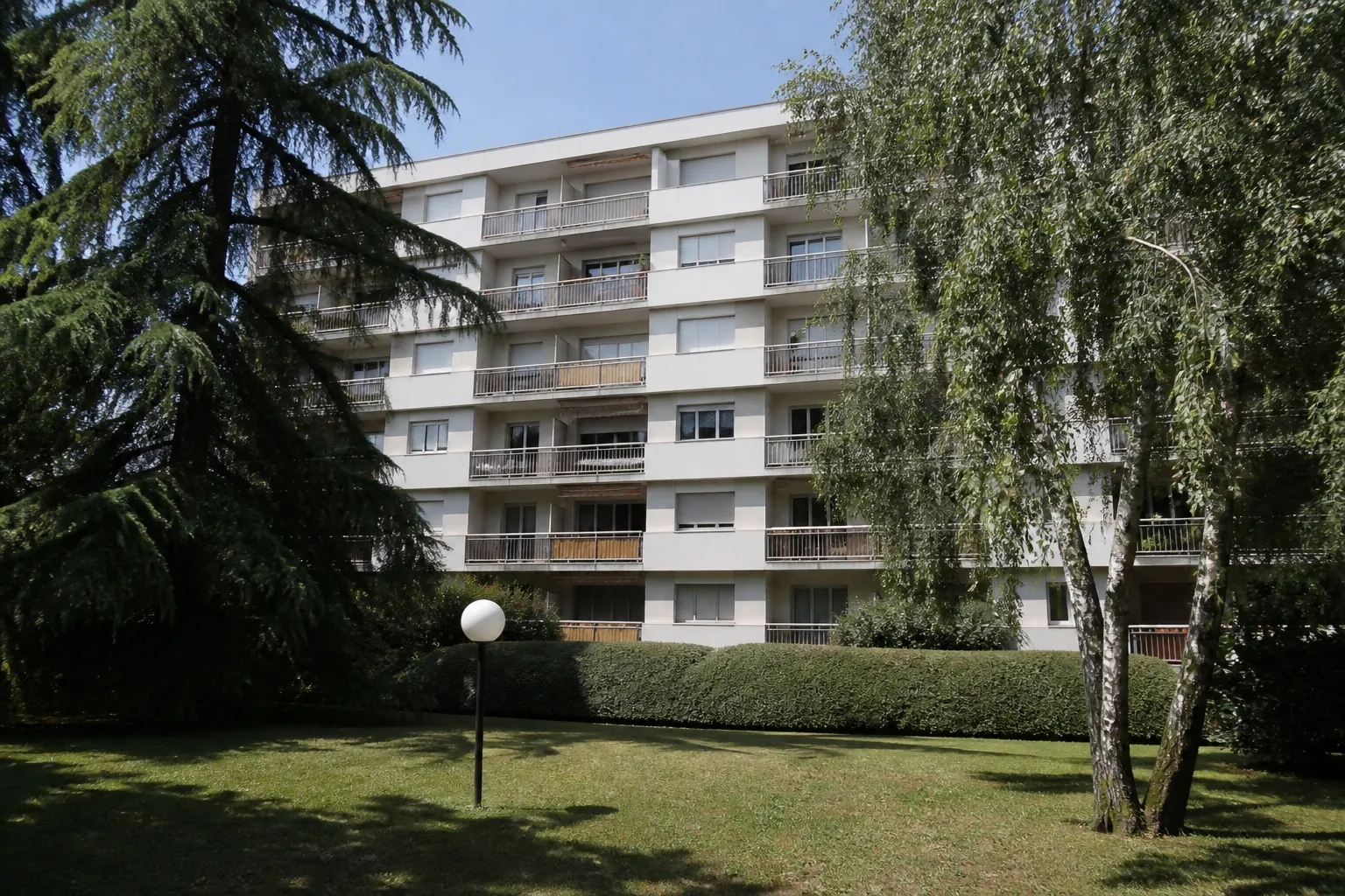 Résidence en copropriété des années 1970 vue depuis un jardin
