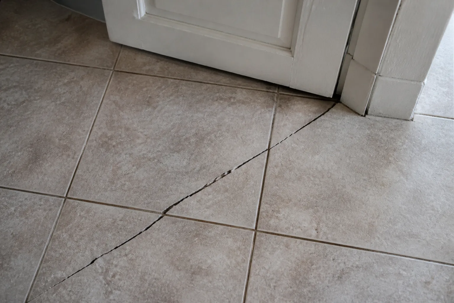 Carrelage fissuré et porte intérieure désaffleurante