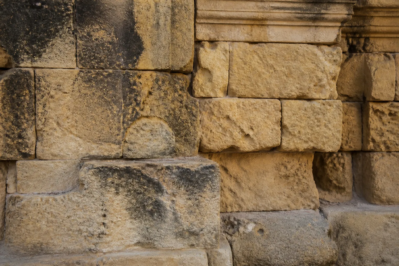 Détail d'une façade en pierre calcaire jaune avec joints dégradés