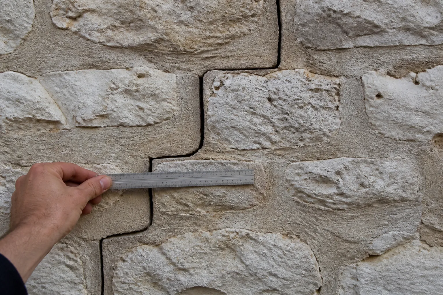 Fissure en escalier sur un mur en moellons relevée par un expert