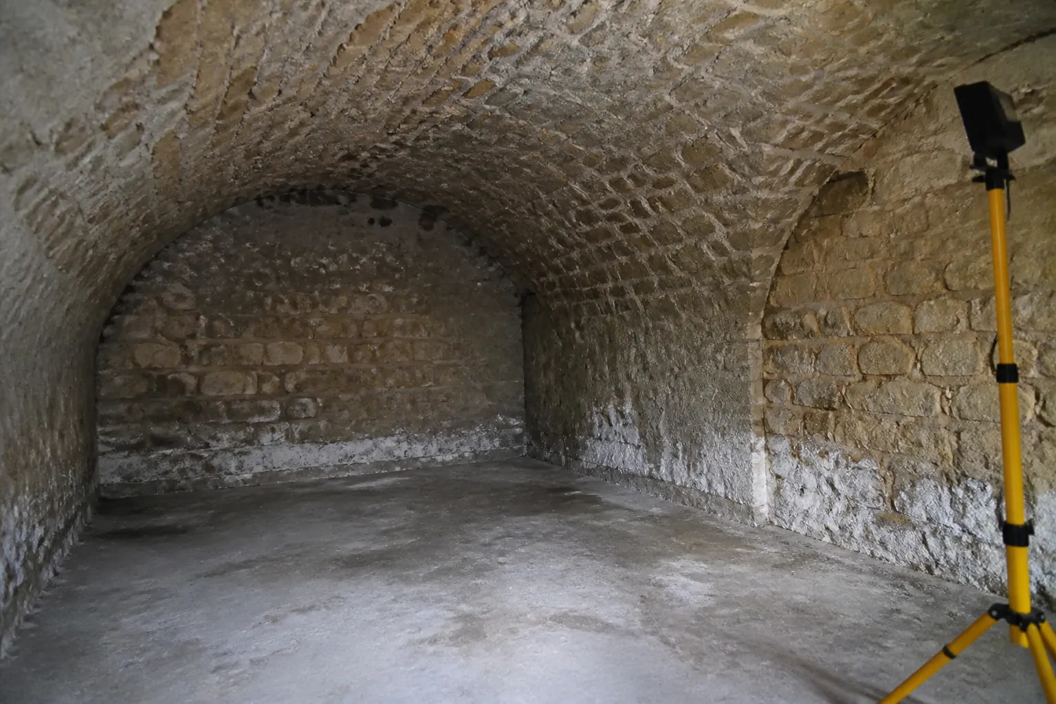Cave voûtée d’un immeuble ancien avec traces d’humidité en pied de mur