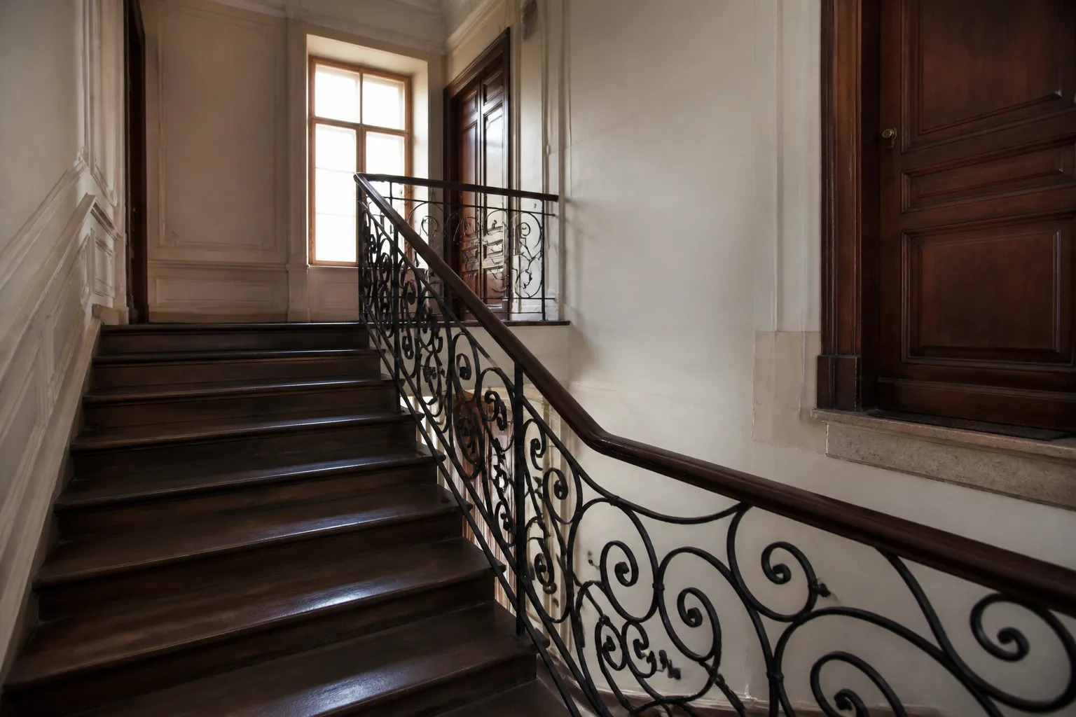 Escalier commun en bois dans une grande maison divisée en appartements