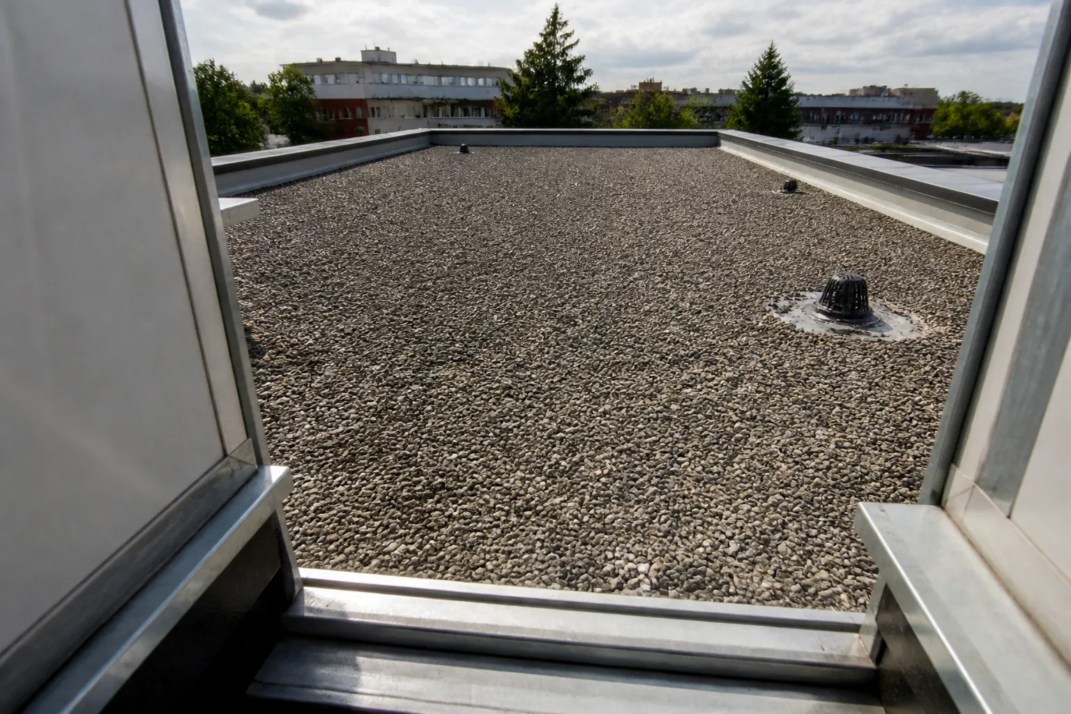 Toiture-terrasse d’un petit immeuble examinée depuis un accès sécurisé