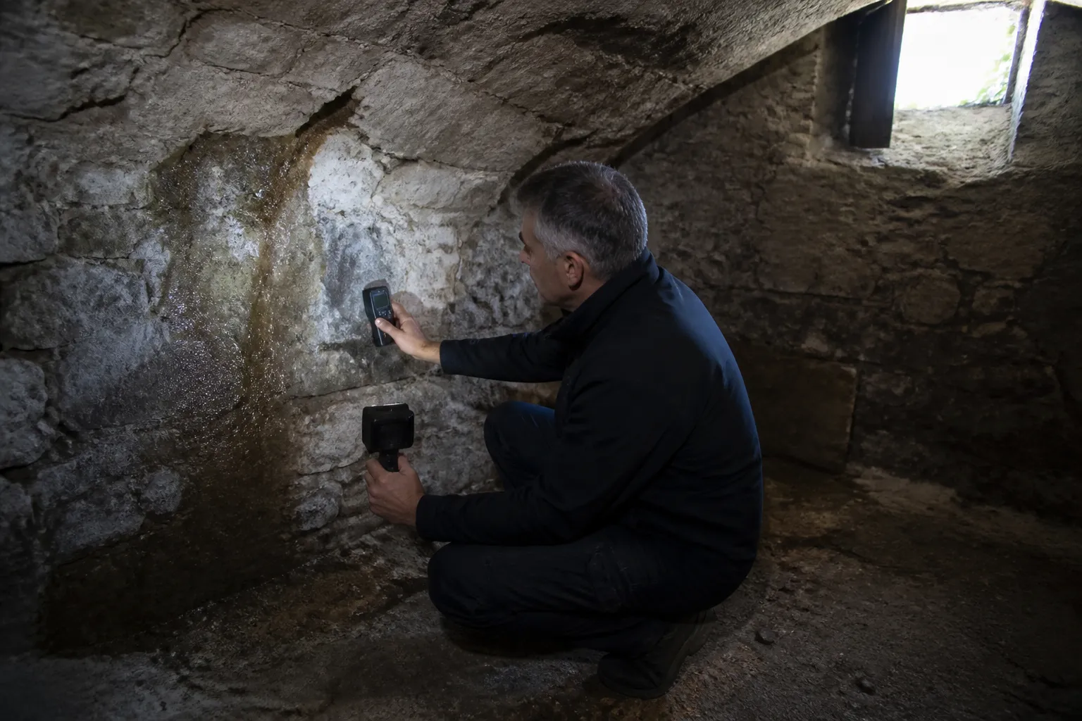 Expert mesurant l’humidité dans une cave voûtée