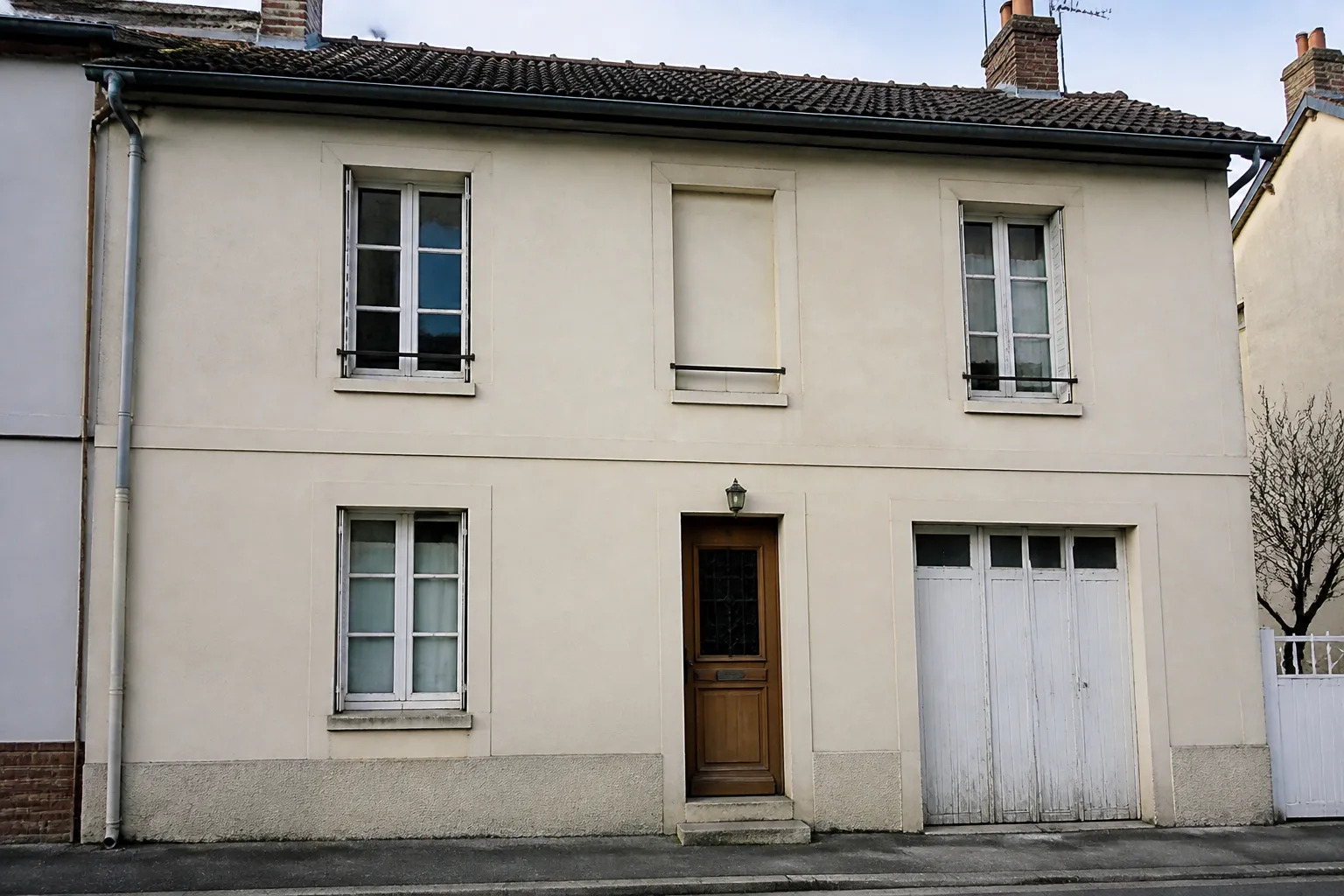 Façade d’une maison d’après-guerre avec enduit et menuiseries d’origine