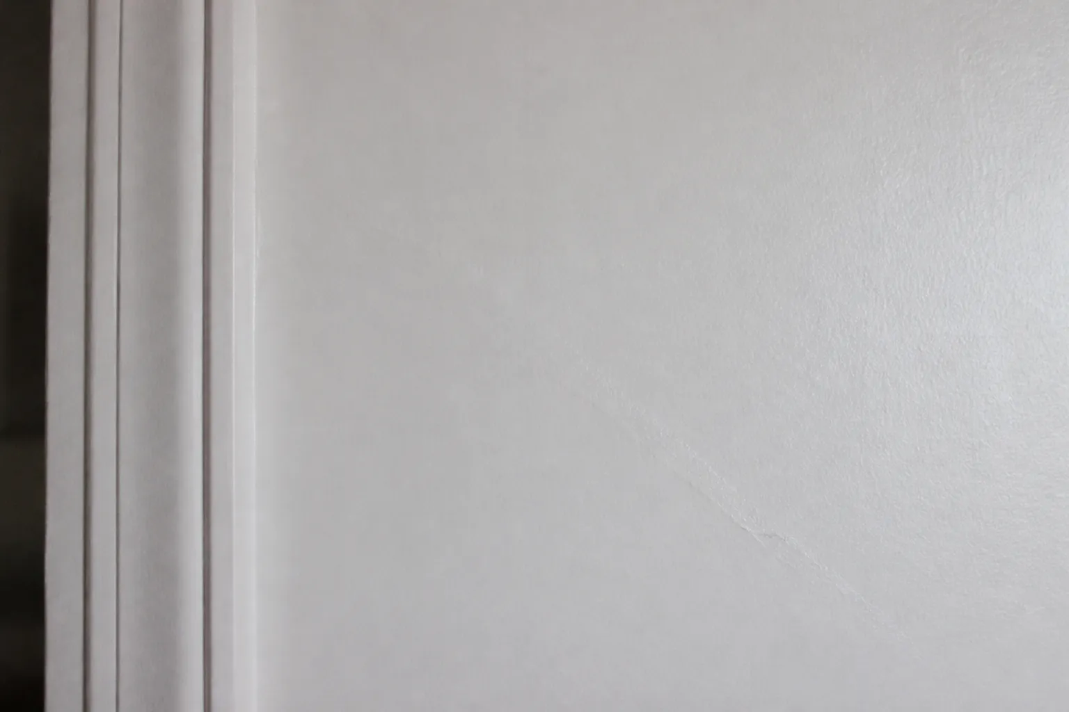 Fissure récemment rebouchée et repeinte sur un mur intérieur