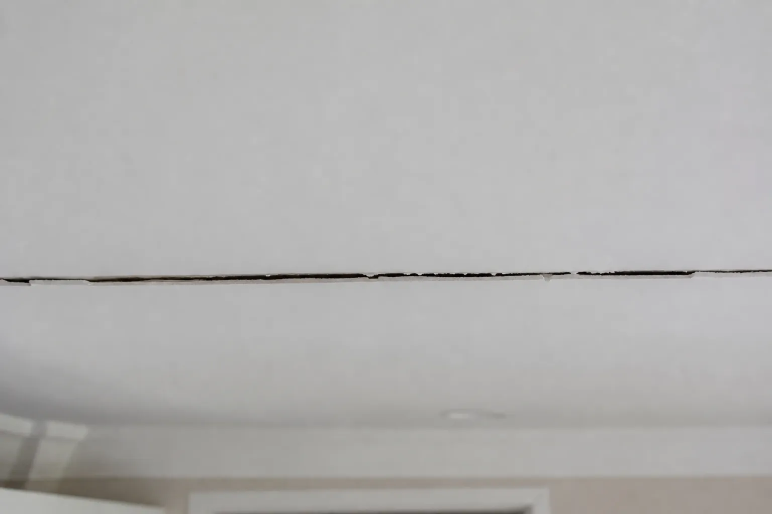 Fissure au plafond le long d'une ancienne cloison supprimée