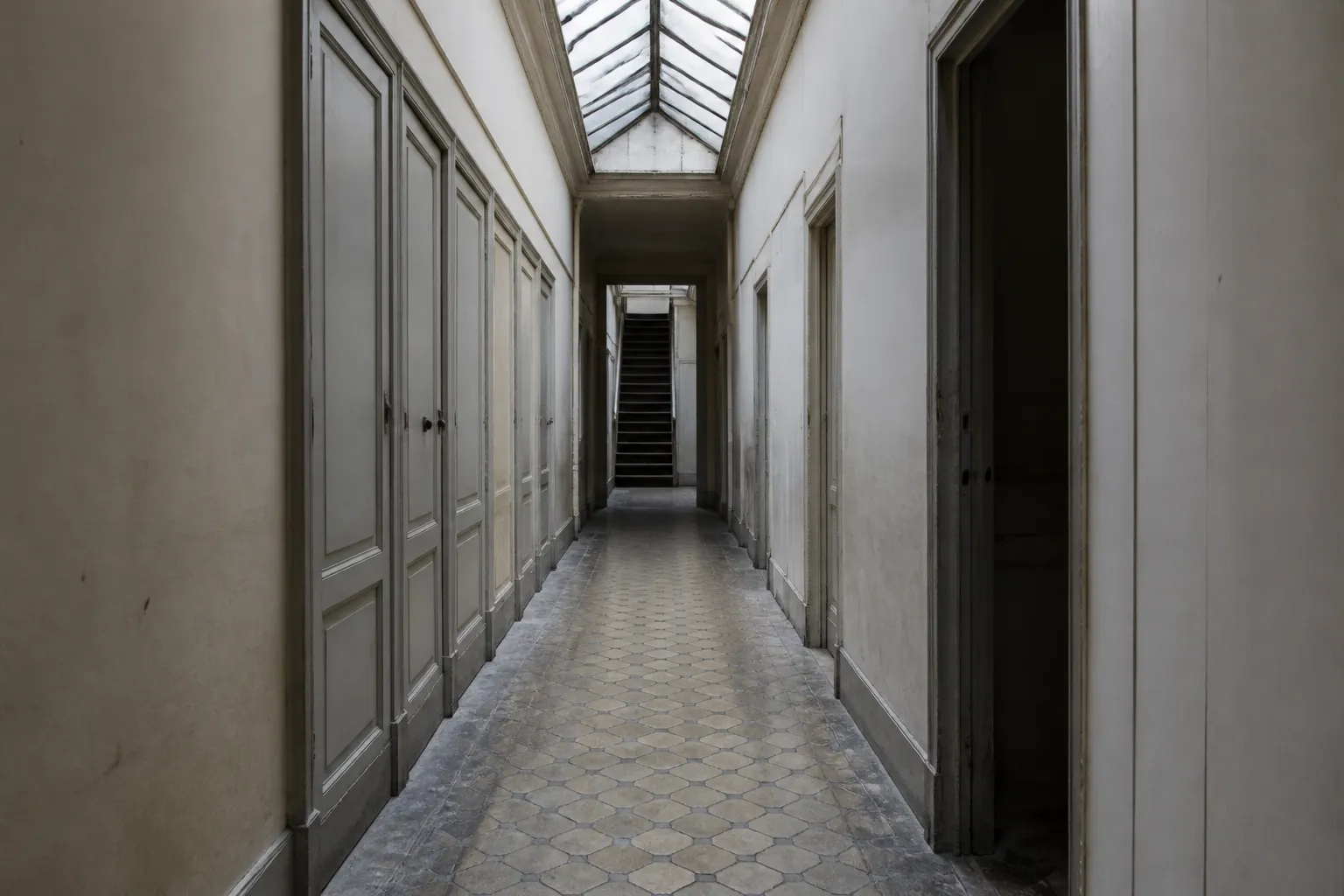 Couloir desservant des chambres de service au dernier étage d'un immeuble ancien